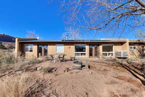 Rear view of house featuring french doors, a patio area, a fire pit, and stucco siding