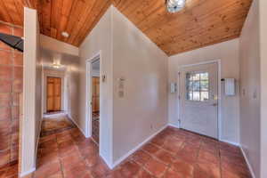 Foyer entrance featuring wood ceiling, lofted ceiling, and tile patterned flooring