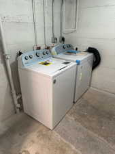 2697 - Laundry room featuring unfinished concrete floors and washer and dryer