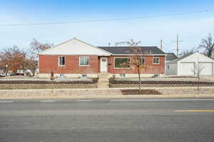 View of front of property with an outbuilding, a garage, and brick siding