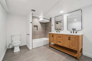 Bathroom with double vanity and shower / washtub combination