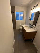 2697 - Full bath with vanity, dark tile patterned flooring, and a tile shower