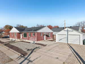 Single story home featuring an outdoor structure, a garage, and brick siding