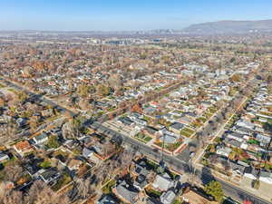 Aerial view of property and surrounding area with mountains and nearby suburban area