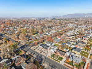 Aerial view of property and surrounding area with a mountain backdrop and nearby suburban area