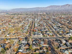 Aerial view of property and surrounding area with mountains and nearby suburban area