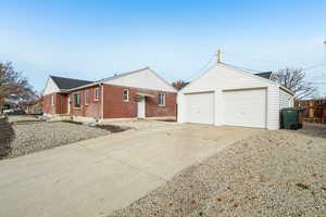 View of front facade featuring an outbuilding and brick siding