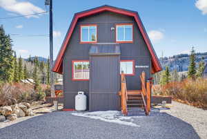 View of front facade with a metal gambrel roof, and a porch