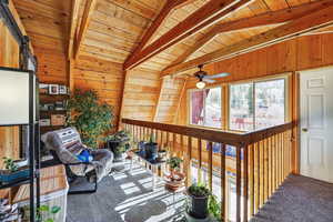 Loft space with ceiling fan and ample natural light