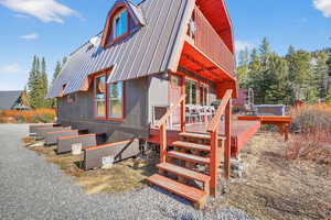 Back of house with a metal roof and a deck