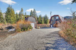 View of dirt / gravel driveway featuring a shed