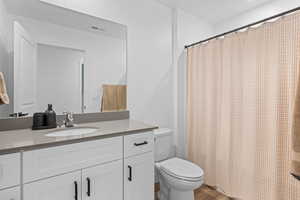 Full bathroom featuring toilet and vanity