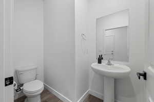 Half bath featuring wood finished floors and baseboards