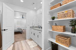 Ensuite bathroom with light wood-style floors, vanity, ceiling fan, and recessed lighting