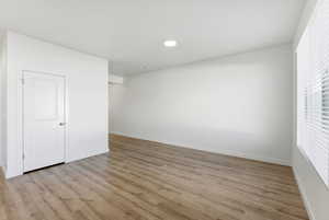 Empty room featuring light wood-style flooring and recessed lighting
