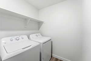 Laundry area featuring washer and clothes dryer and wood finished floors