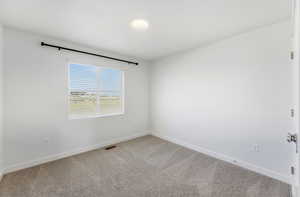 Spare room with light colored carpet and baseboards