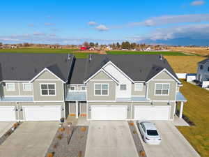 View of front of house with concrete driveway, a shingled roof, a metal roof, a standing seam roof, and board and batten siding