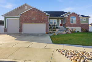 Ranch-style house featuring a front yard, a garage, concrete driveway, covered porch, and brick siding