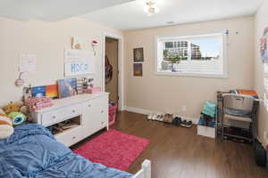 Bedroom with dark wood finished floors and baseboards