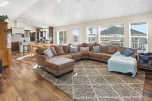 Living area featuring lofted ceiling, a chandelier, dark wood-type flooring, and recessed lighting
