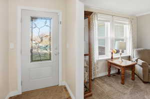Doorway with healthy amount of natural light and carpet