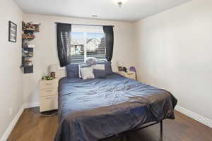 Bedroom with baseboards and dark wood-style floors
