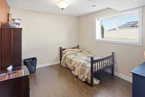 Bedroom featuring dark wood-type flooring and a textured ceiling