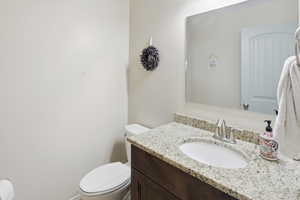 Half bathroom featuring vanity and toilet