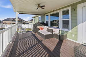 Deck featuring a ceiling fan, grilling area, an outdoor hangout area, and a residential view