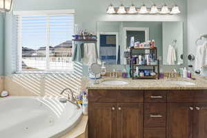 Bathroom featuring double vanity and a tub with jets
