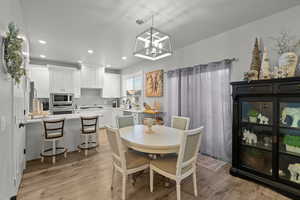 Dining area featuring recessed lighting, light wood-style floors, and a chandelier