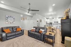 Living area with recessed lighting, a ceiling fan, light wood-style floors, a wainscoted wall, and a decorative wall