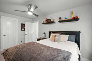 Carpeted bedroom featuring a ceiling fan