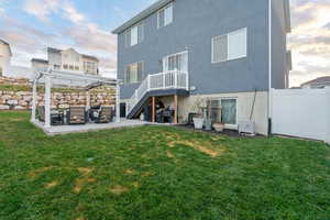 Rear view of house with a patio, stucco siding, and a yard