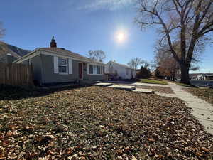 Bungalow-style home with a chimney and brick siding