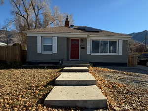 View of front of home with solar panels, a chimney, a mountain view, and brick siding