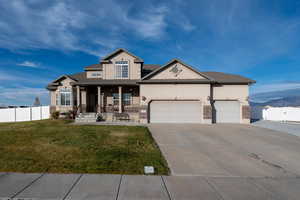 View of front of home with covered porch, stucco siding, concrete driveway, a 3 car garage, and extended RV parking.