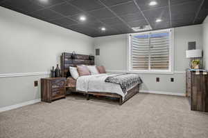 Bedroom featuring carpet flooring and a drop ceiling