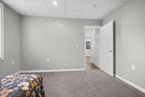 Carpeted bedroom featuring a paneled ceiling and recessed lighting
