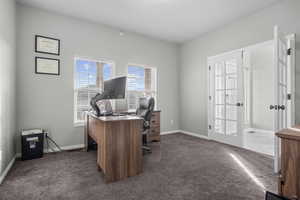 Home office with french doors and dark carpet