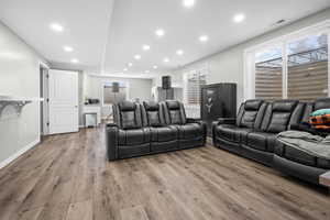 Cinema with recessed lighting, plenty of natural light, and light wood-style floors