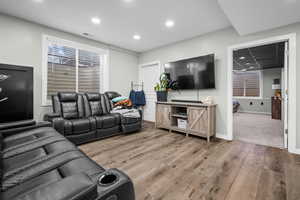 Living room with light wood finished floors and recessed lighting