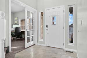 Foyer featuring light marble finish flooring and baseboards