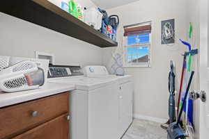 Main level aundry room with washer and dryer and cabinet space