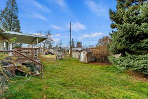View of yard with a wooden deck and a storage shed