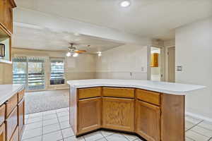 Kitchen featuring brown cabinetry, light countertops, and light tile patterned floors