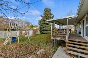 Fenced backyard with a wooden deck and a playground
