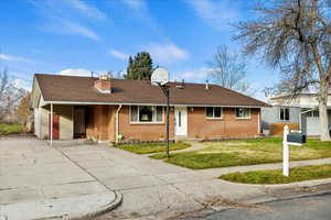 Single story home with roof with shingles, a front yard, brick siding, and a chimney