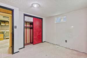 Unfurnished bedroom featuring light flooring, a closet, and a textured ceiling